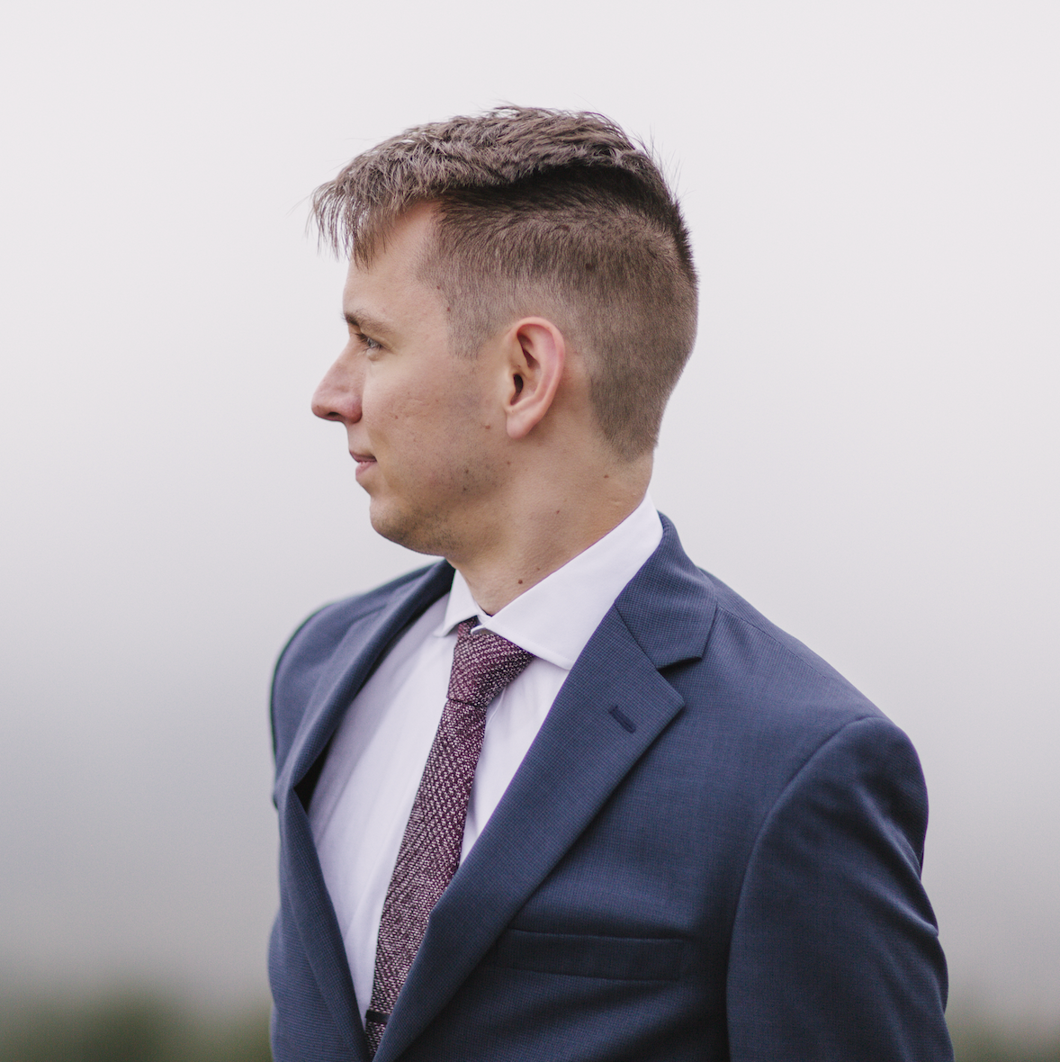 picture of Elijah in suit with cloudy background